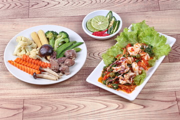 Fried chicken mixed vegetables served with fried spicy squid  mixed herb. 