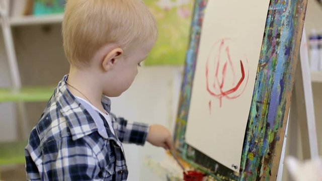 A small child draws with his left hand. The kid learns to draw.