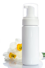 bottle with  lotion and flowers isolated on white