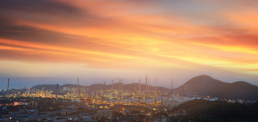 Obraz premium oil refinery, fuel manufacturer with city on beautiful sunset ba
