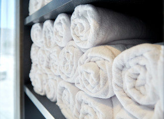Obraz na płótnie Canvas rolled white bath towels at hotel spa