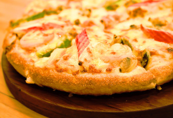 Pizza hawaiian seafood on wooden plate background - Unhealthy and Junk food. soft blur.