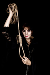 mysterious young woman holding loop of the rope. on a dark background