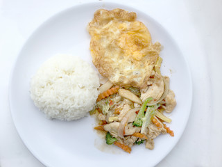 stir fry vegetables with chicken fillet, fried egg with rice in white dish on white background.