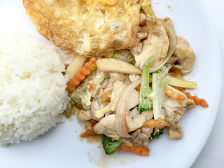 stir fry vegetables with chicken fillet, fried egg with rice in white dish on white background.