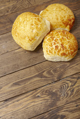 Freshly baked bread rolls on a rustic wooden dinner table background forming a page border