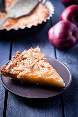 Slice of homemade apple pie on a blue wooden background. Autumn fruit pie