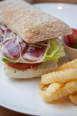 Sandwich with ham, cheese, fresh tomato and green salad