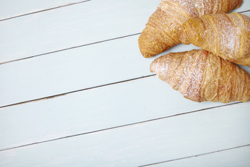 Freshly baked croissants arranged on a wooden breakfast table background 