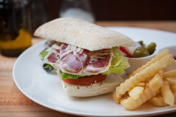 Sandwich with ham, cheese, fresh tomato and green salad