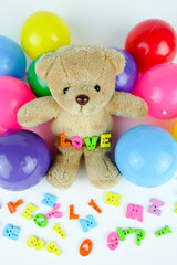 Brown bear doll with colorful ball and letters 