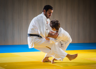 Man and young boy are training judo throw