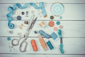 Old scissors, buttons, threads, measuring tape and sewing suppli - obrazy, fototapety, plakaty