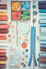 Tools and accessories for sewing on light wooden background. - obrazy, fototapety, plakaty