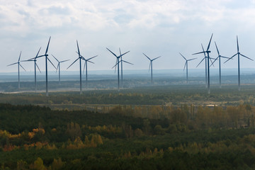 Group of windmills for renewable electric energy production in a hazy autumn day.