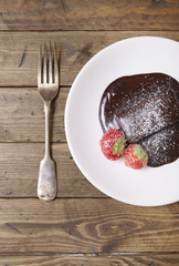 A hot chocolate fudge brownie dessert on a reclaimed wooden table background