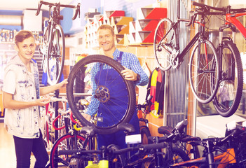 Smiling man repairing bike wheel and chatting