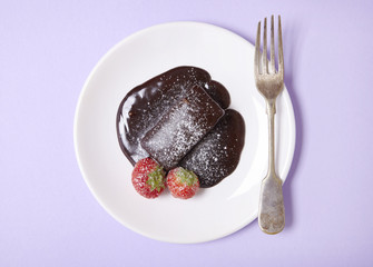 A hot chocolate fudge cake dessert on a pastel purple background