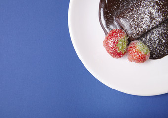 A hot chocolate fudge brownie dessert on a bright blue background forming a page background