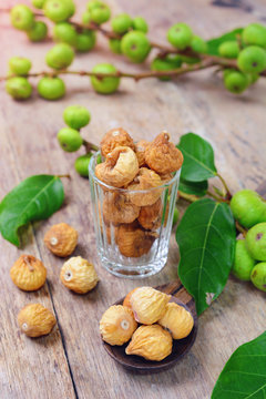 dried figs and fresh fruit on a wooden table. (ficus carica, ficus racemosa, ficus glomerata)