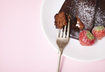 A chocolate fudge brownie pudding on a pastel pink background forming a page border