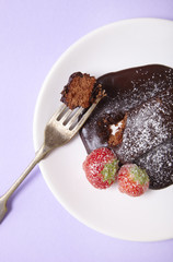 A chocolate fudge brownie dessert on a pastel purple background