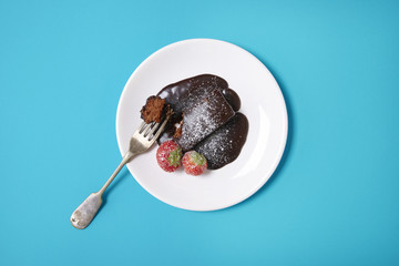 A chocolate fudge cake pudding on a bright blue background