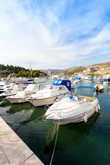 Fototapeta na wymiar Beautiful sunny day over the bay in front of old town of Dubrovnik. Pier with boats.