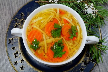 Hot traditional chicken soup in a white dish served at Christmas dinner
