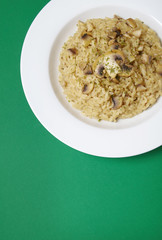 A dinner dish of mushroom risotto on a bright green background forming a page header