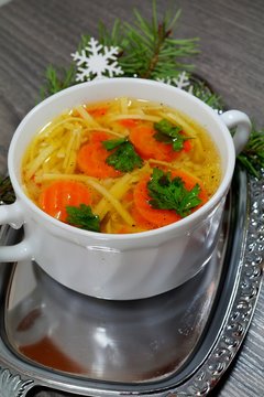 Hot traditional chicken soup in a white dish served at Christmas dinner
