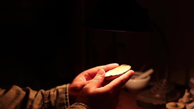 Ceramic artist checking his work in the dark room