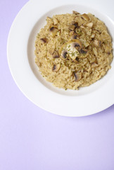 A dinner dish of chicken and mushroom risotto on a pastel purple background forming a page header