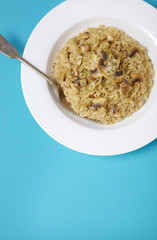 A dish of mushroom risotto on a bright blue background forming a page header
