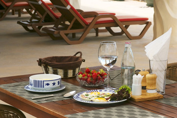 Breakfast with sunny-side up eggs and strawberries at the beach