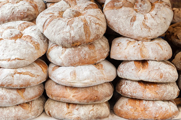 rustic bread in the foreground baked and placed in piles