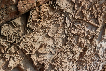 Brown stone texture background. Cracked and weathered natural stone background.