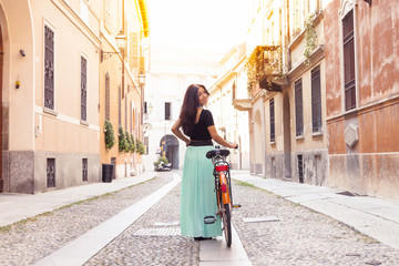 Naklejka premium young girl turns with the bike on the streets of a city