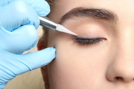 Cosmetologist making permanent makeup, close up