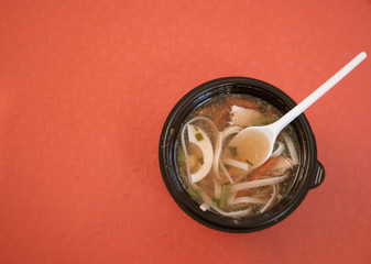 Ramen soup on red background top view.