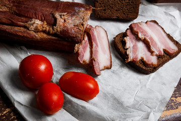Smoked bacon with rye black bread and tomatoes on the packaging