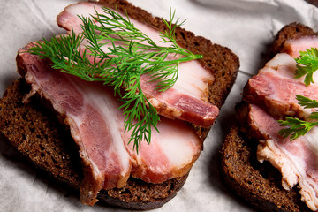 Slices of smoked bacon with rye black bread on the white packagi