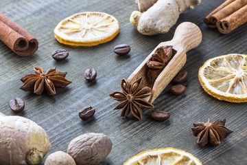 star anise, dried lemon, cinnamon, ginger and coffee beans with wooden spoon on wooden table.