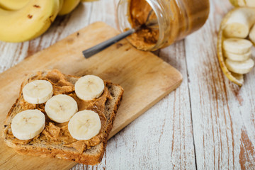 Homemade peanut butter and banana sandwich on wooden background