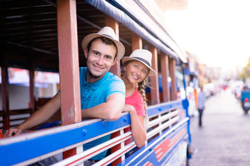 Traveling Asia. Young handsome man with his girlfriend in traditional thai bus.