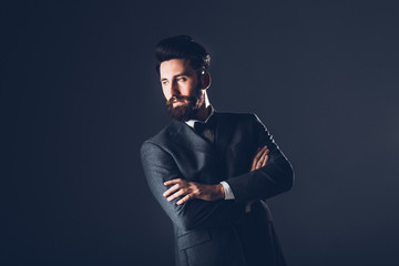 Young handsome bearded caucasian man posing indoors. Perfect skin and hairstyle. Wearing elegant...