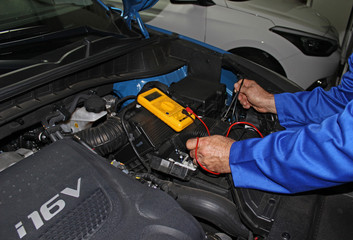 Fototapeta premium Mecánico comprobando la bateria del coche