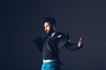 Young handsome bearded caucasian man posing indoors. Perfect skin and hairstyle. Wearing elegant...