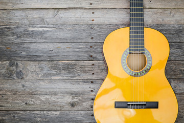 Obraz premium brand new classical guitar on old wooden plank background