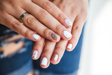 Beautiful manicure of gel varnish. Golden White. Fashion, style, care